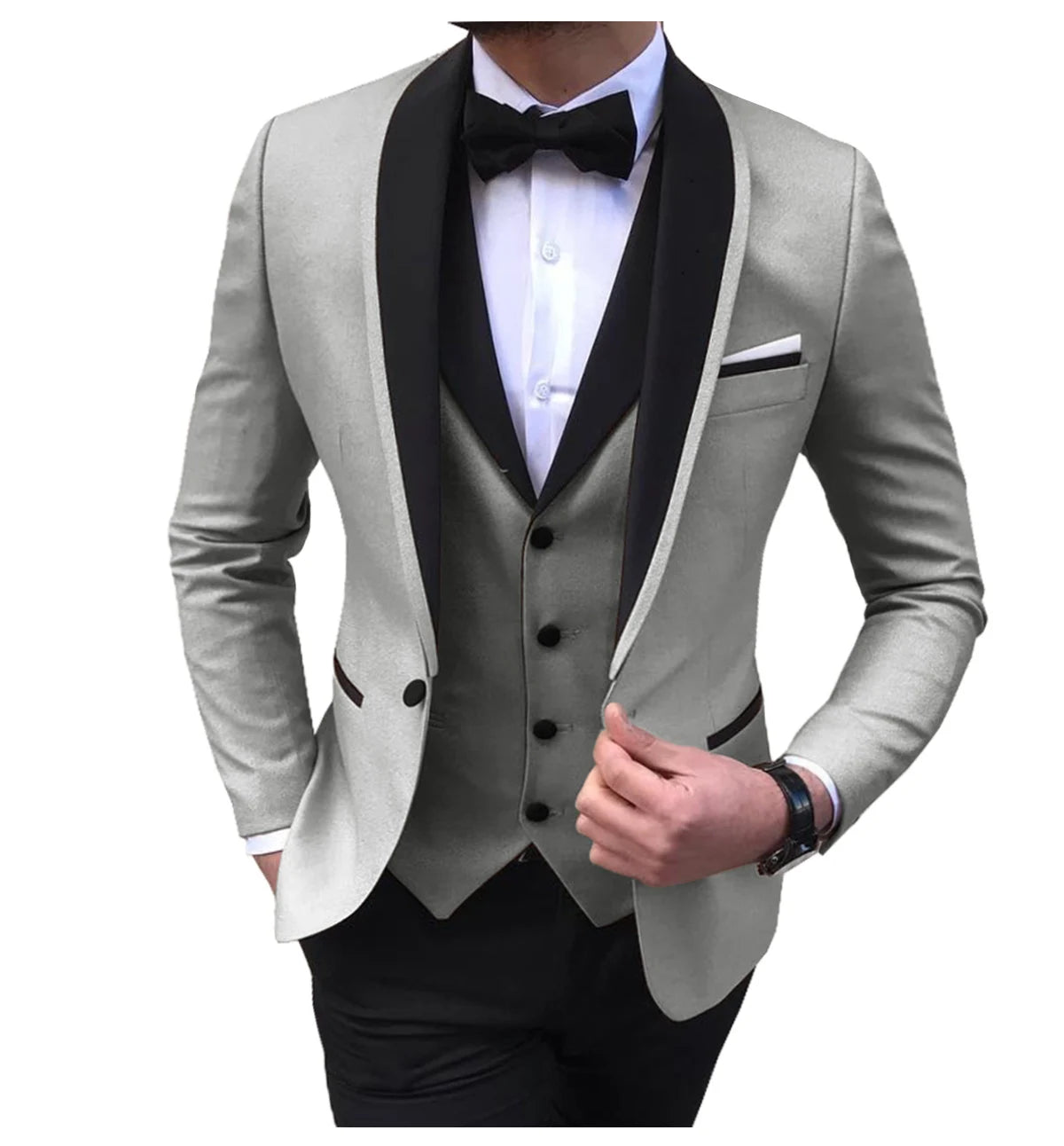Man in a light gray tuxedo with black lapels, wearing a white shirt, black bow tie, and matching vest. His left hand adjusts the jacket, revealing a pocket square.