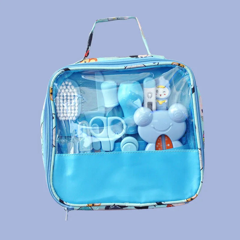Blue baby care kit in a clear front zippered bag, containing a brush, comb, scissors, and a thermometer. The bag features a playful cartoon animal design.