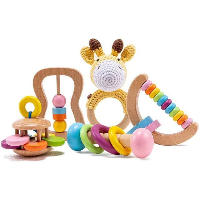 A set of colorful wooden baby rattles and teethers, including a knit giraffe, an abacus-style ring, and a multi-ring toy, all with vibrant beads and pastel colors.