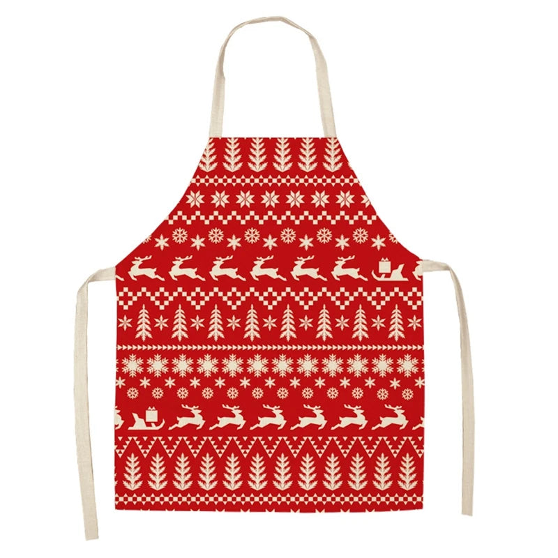 Red apron with white Nordic-style patterns featuring reindeer, trees, and geometric designs. Cream-colored neck and waist straps add contrast.