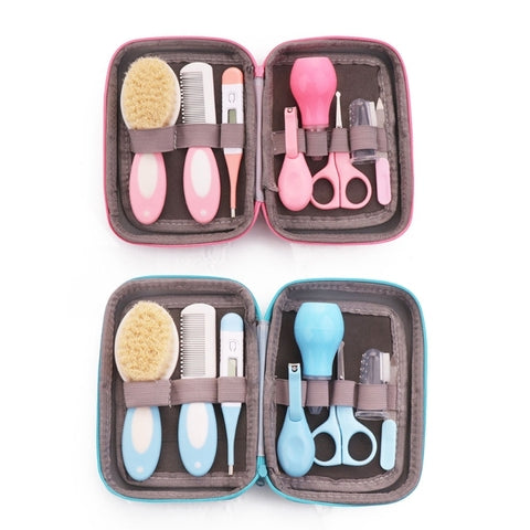 Two open baby grooming kits are shown. The top kit is pink, containing a brush, comb, scissors, nail clippers, and more. The bottom kit is blue, featuring similar grooming items.
