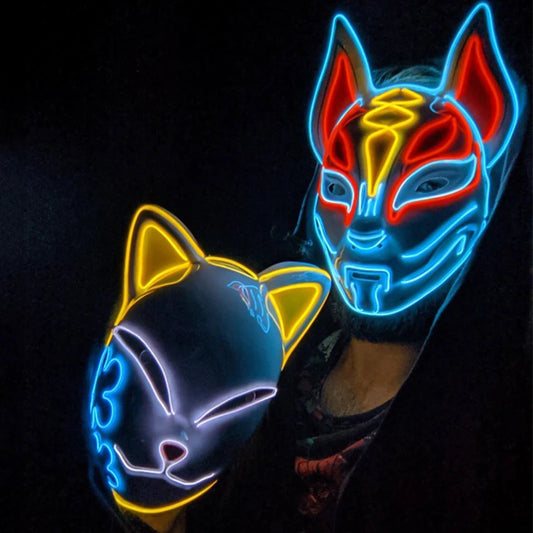 Two people wearing illuminated masks: one with a feline shape featuring yellow and blue outlines, and another with a futuristic design in blue, red, and yellow lines.