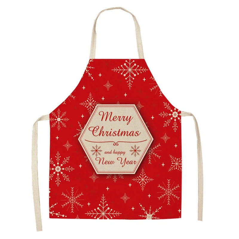 Red Christmas apron with white snowflakes and a hexagonal emblem that reads "Merry Christmas and happy New Year" in elegant script. Cream-colored neck and waist ties.