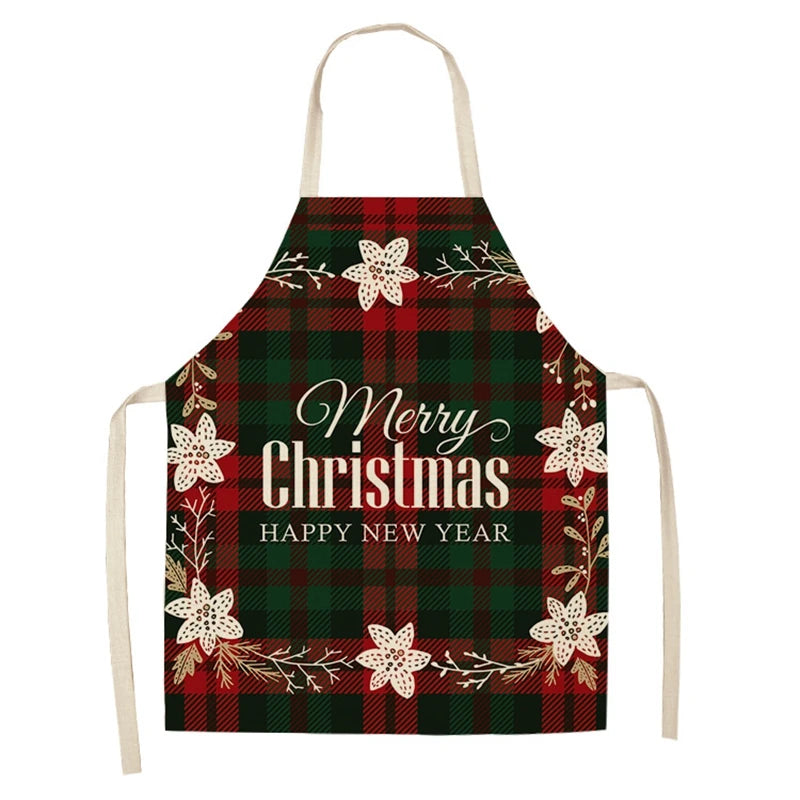 Red and green plaid apron with "Merry Christmas" and "Happy New Year" text. Decorated with white poinsettia-like flowers and branches. Cream-colored straps.