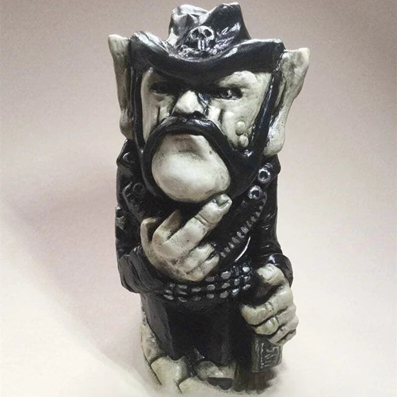 Ceramic gnome sculpture with exaggerated features, wearing a black leather outfit and a hat adorned with a skull. The gnome has a distinctive mustache and sideburns, holding a bottle.