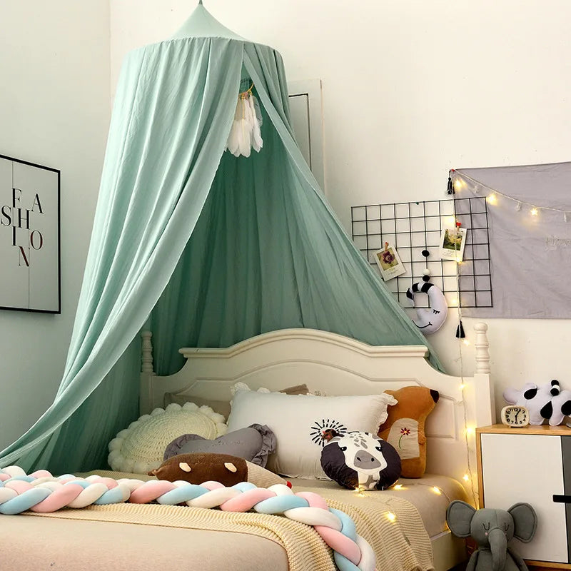 Cozy children's bedroom with a canopy over the bed, adorned with plush animal pillows and a rope of pastel fabric on the blanket. Soft lighting and wall decor enhance the room.