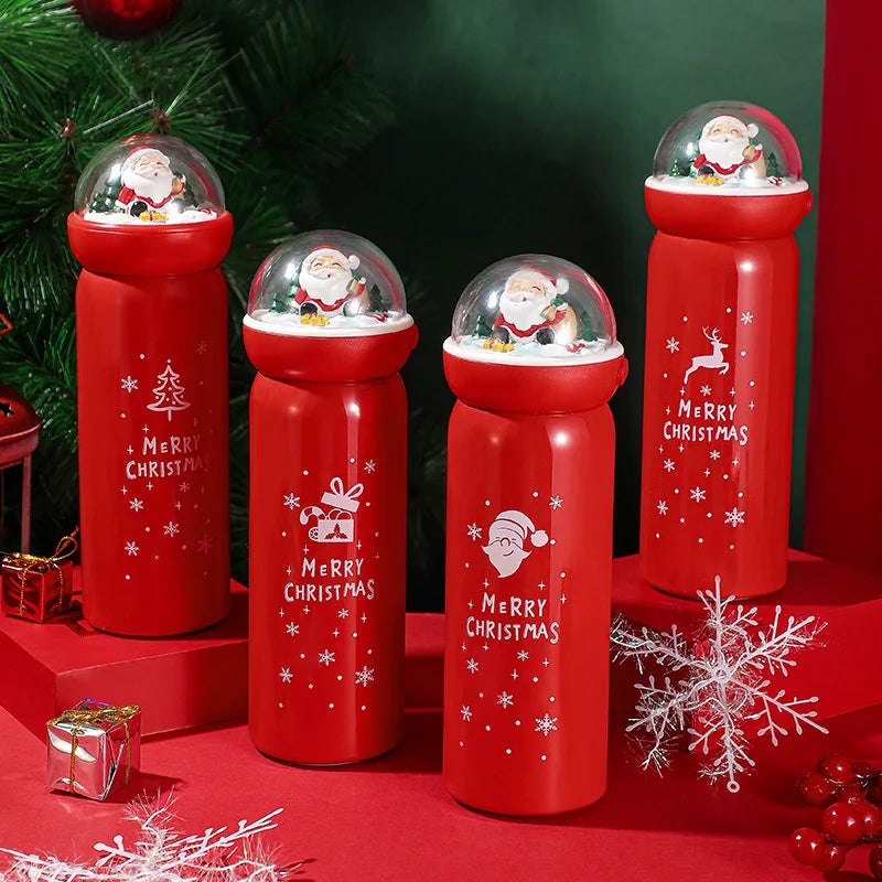 Five red Christmas-themed thermoses with snow globe lids featuring Santa Claus figures. Each bottle is decorated with festive designs and "Merry Christmas" text.