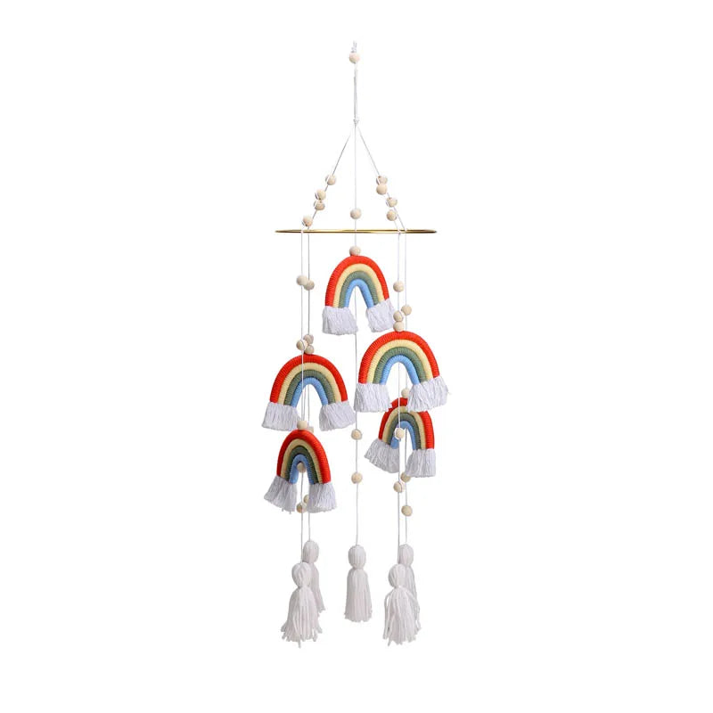 Colorful rainbow-themed mobile with six fabric rainbows, white tassels, and wooden beads, hanging from a wooden bar. Perfect for nursery decor against a plain white background.