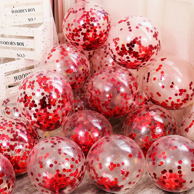 Clear balloons filled with red confetti clustered together beside stacked wooden boxes labeled "WOODEN BOX." The scene suggests a festive or party setting.
