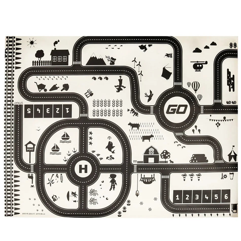 Black and white road map playmat with a looping road, houses, farms, animals, a helicopter pad, and various playful icons. Features start and finish lines with a racing theme.