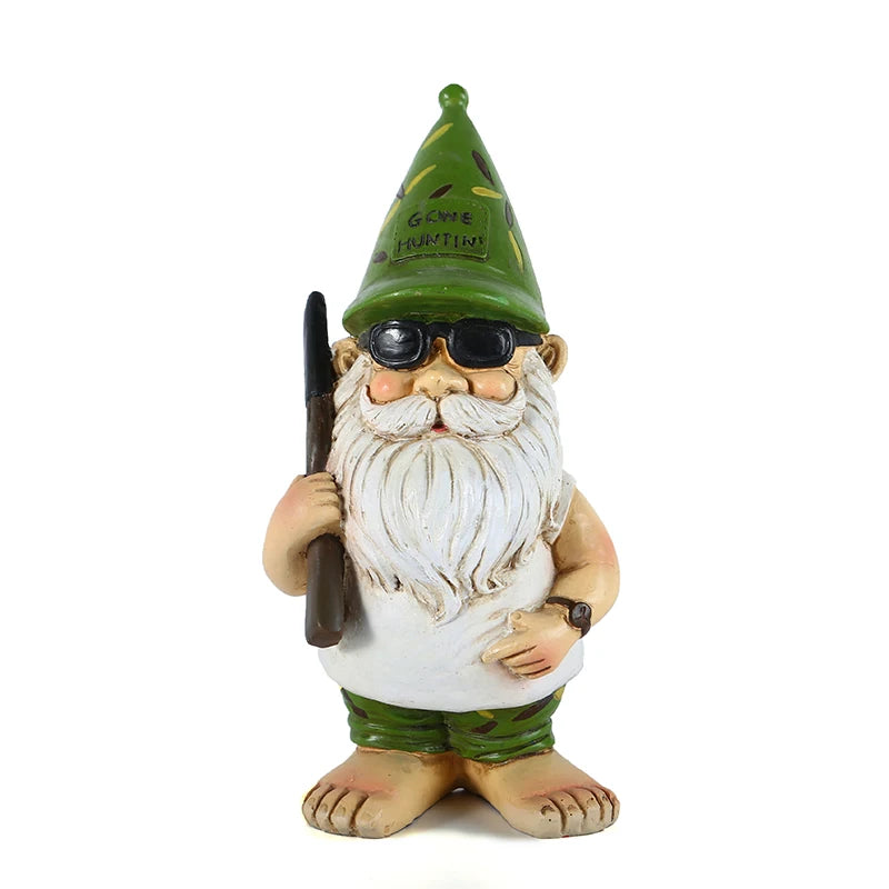 Garden gnome with a white beard, wearing sunglasses and a green hat that reads "Gone Huntin'." He holds a rifle and wears camouflage shorts, standing barefoot.