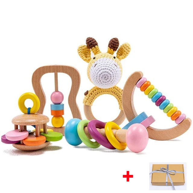 Set of wooden and crocheted baby toys, featuring a giraffe rattle, ring stacker, and rainbow abacus, displayed with a gift box tied with a gray ribbon.