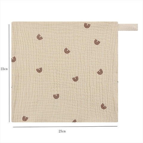 A beige, textured cotton cloth measuring 23x23 cm with a loop for hanging. It features small, scattered brown arc patterns on a grid-like surface.