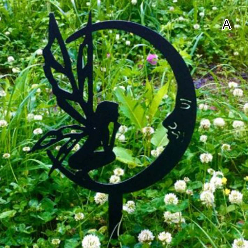 Silhouette of a fairy with wings sitting on a crescent moon, set against a backdrop of lush green grass and white clover flowers.