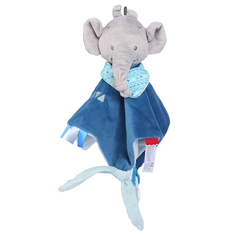 Plush gray elephant toy with floppy ears, wearing a patterned blue scarf, attached to a soft blue blanket. The blanket features ribbon tags and embroidered shapes.