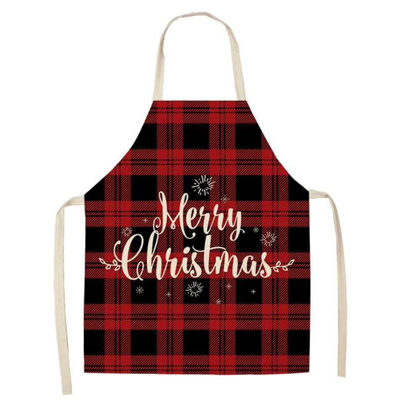 Red and black plaid apron with festive "Merry Christmas" text in white, adorned with small star and swirl accents. Beige neck and waist straps.