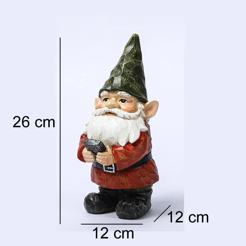 A 26 cm tall garden gnome figurine with a green pointed hat, white beard, and red coat, holds a black object. The base measures 12 cm in width and length.