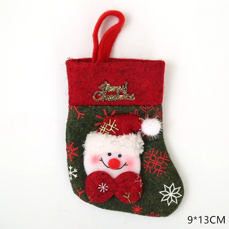 Green and red Christmas stocking with a Santa face, snowflakes, and "Merry Christmas" text. Features a red hanging loop and measures 9x13 cm.