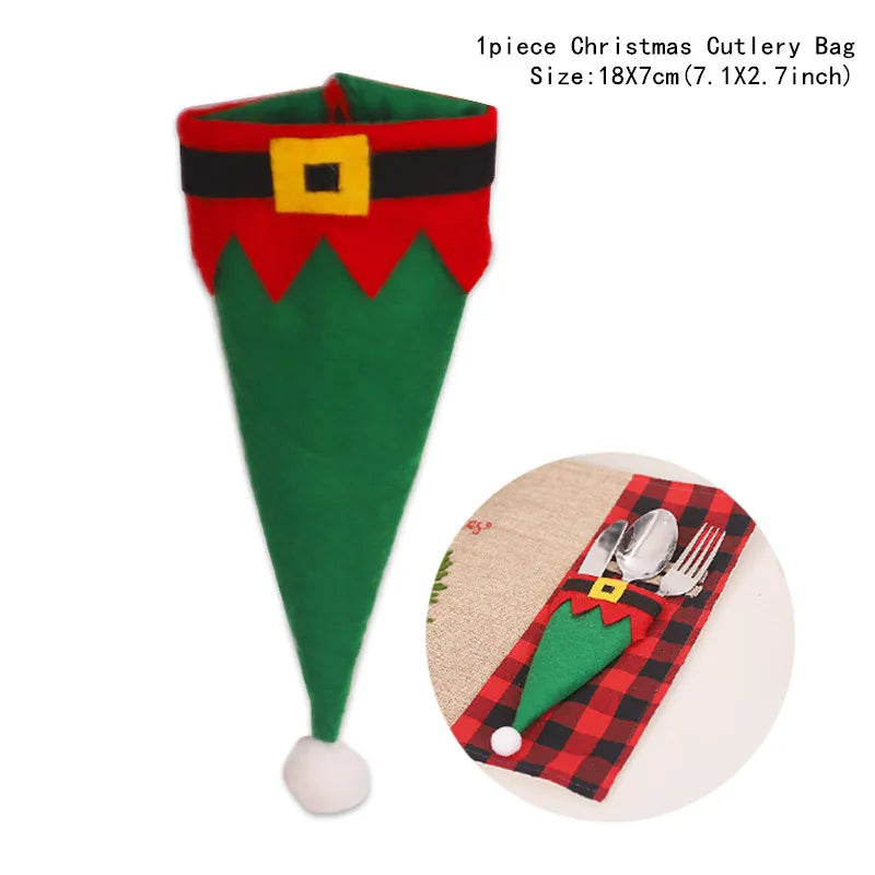 Green and red elf-themed cutlery bag with a belt buckle design, used to hold utensils. Dimensions: 18x7 cm. Inset shows the bag on a plaid placemat with cutlery.