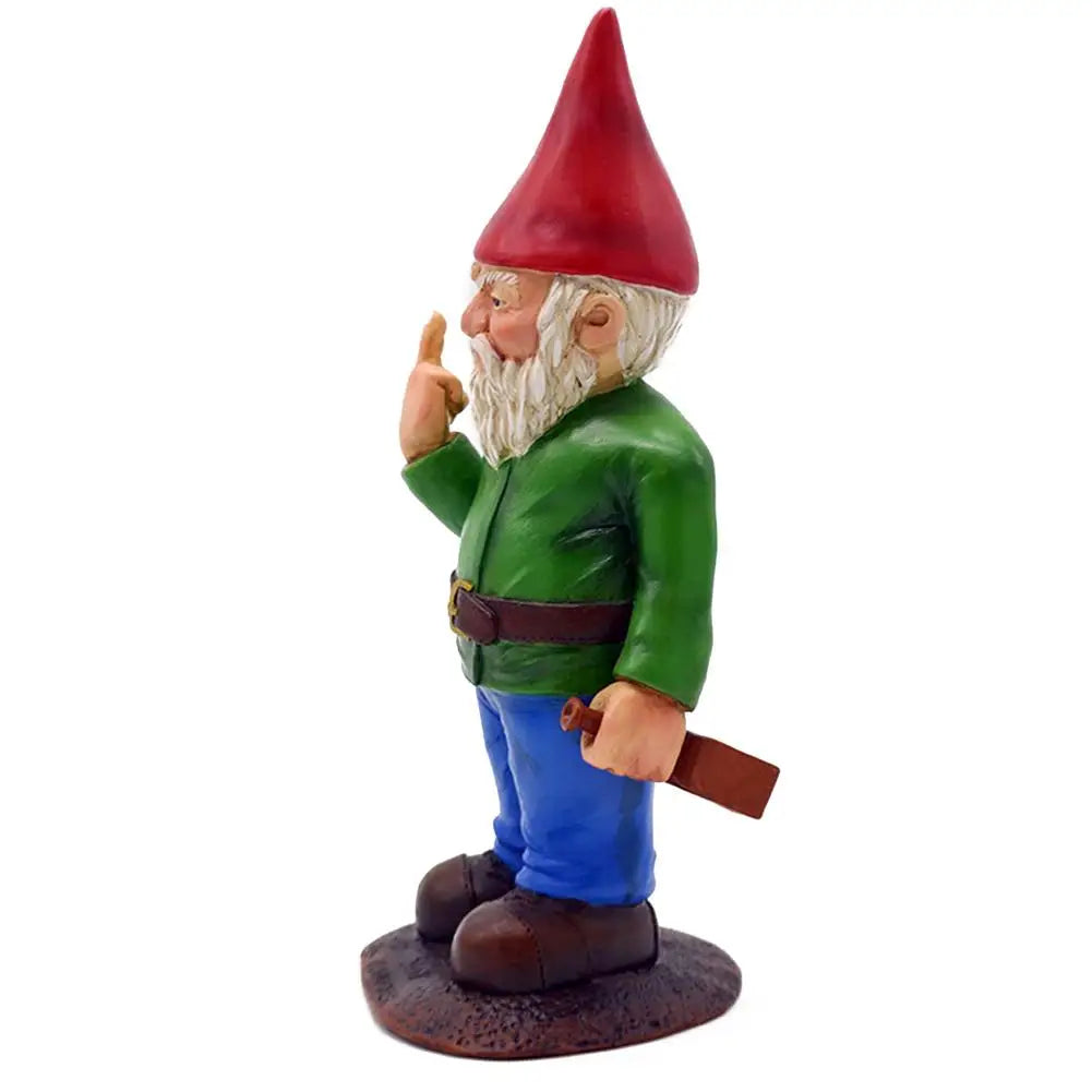 A garden gnome figurine with a red hat, green shirt, and blue pants stands on a base, holding a brown tool and raising a hand in a gesture.