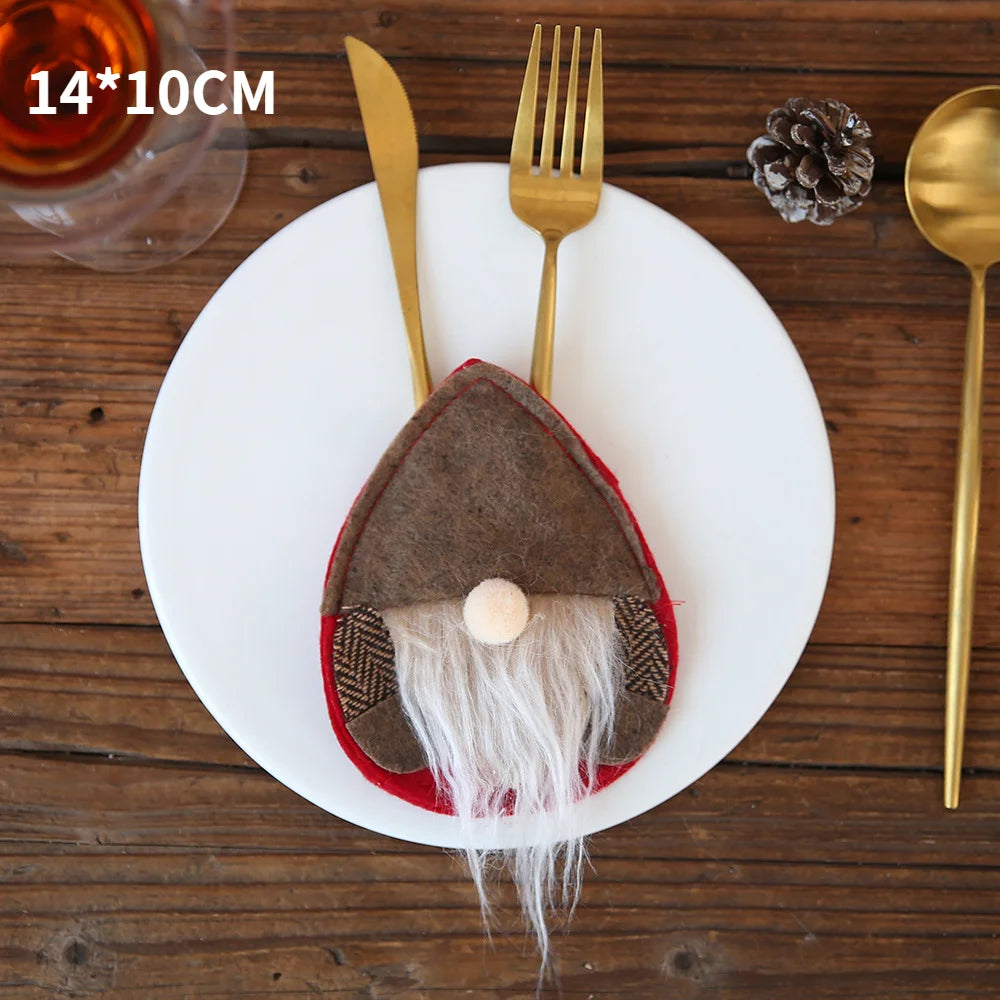 Gnome-themed cutlery holder with fork and knife on a white plate, next to a golden spoon and a pinecone, on a wooden table. Measures 14x10 cm.