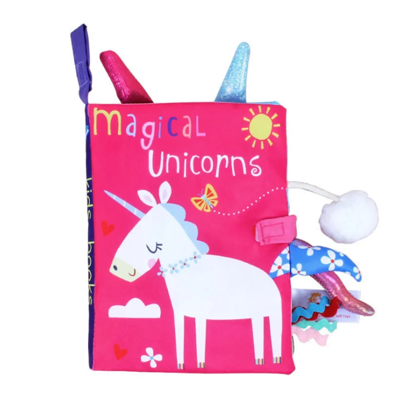 Bright, colorful cloth book titled "Magical Unicorns" featuring a white unicorn with blue mane and tail. Sun, clouds, hearts, and butterflies adorn the pink cover.