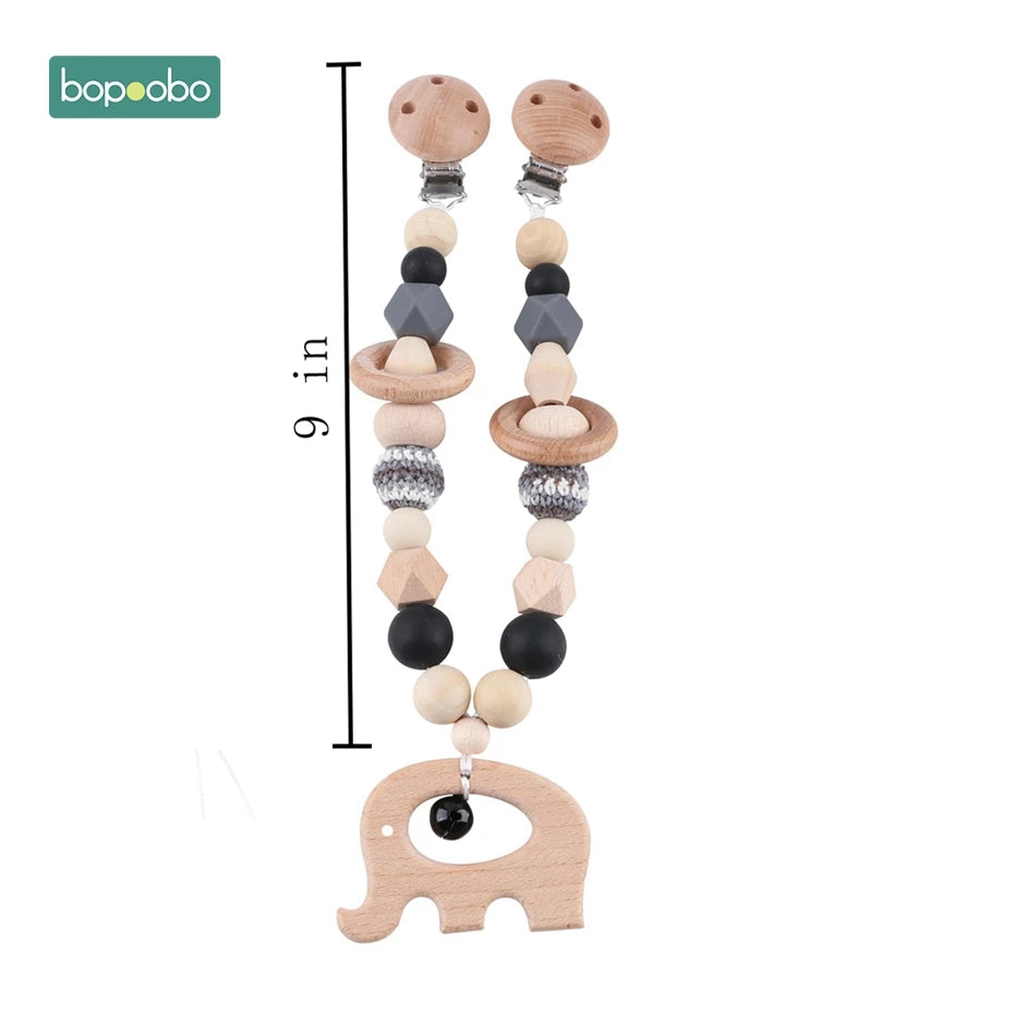 A 9-inch wooden pacifier clip with beads in various shapes and colors, featuring a wooden elephant at the end, and a "bopoobo" logo in the top left corner.