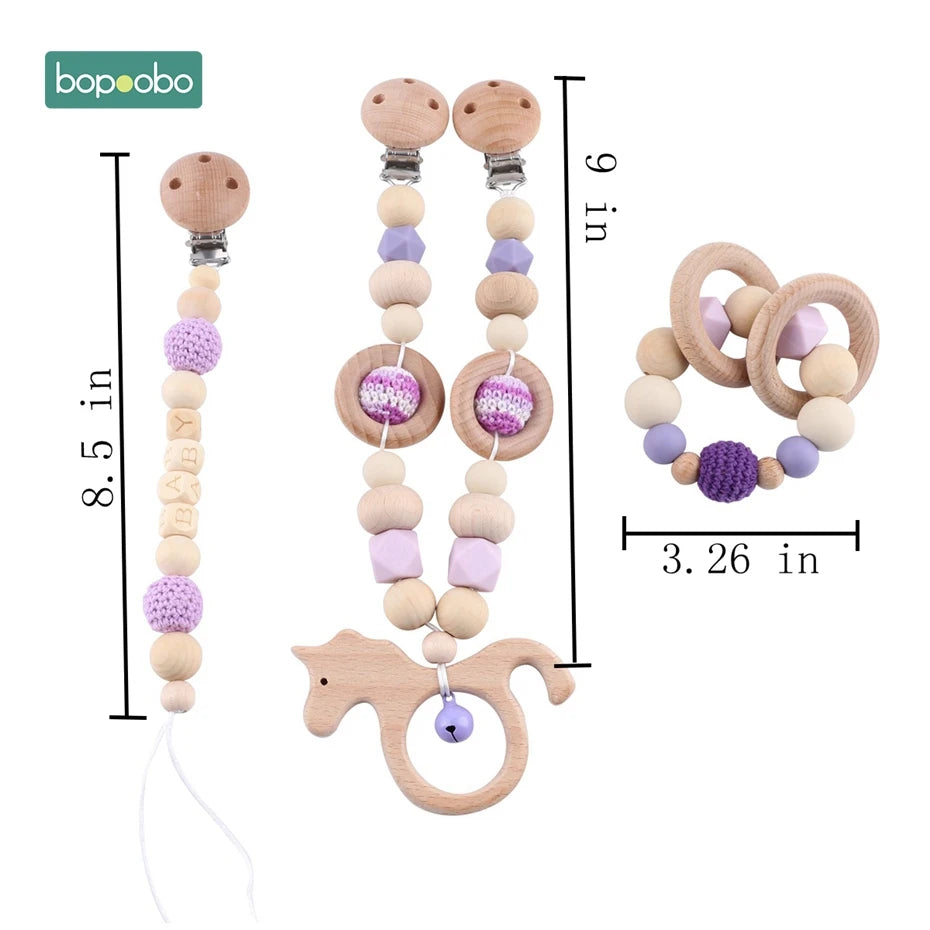 Wooden baby pacifier clips with lilac and natural beads, labeled 8.5 and 9 inches. A matching teething ring with crochet beads is 3.26 inches. Bopoobo branding included.