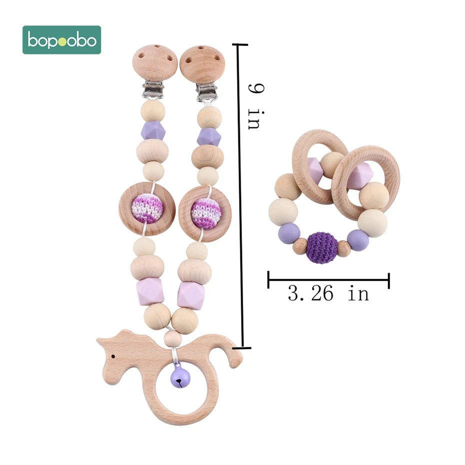 Wooden baby pacifier clip and teething toy set. Clip measures 9 inches, featuring beads and a horse shape. Teething ring is 3.26 inches, with wooden and purple beads.