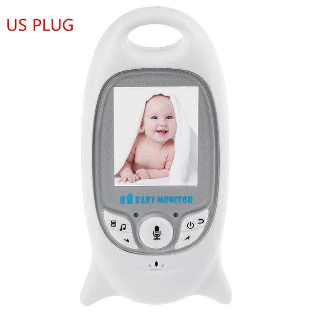 White baby monitor with a screen displaying a smiling baby under a towel. The monitor has control buttons below the screen and "US PLUG" written in the top left corner.