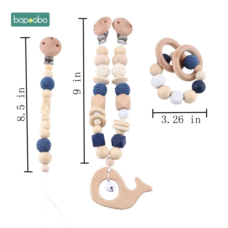 Wooden pacifier clips, 8.5 and 9 inches, and a teether ring measuring 3.26 inches. Features wood and crochet beads, including "BABY" letters and a whale-shaped charm.