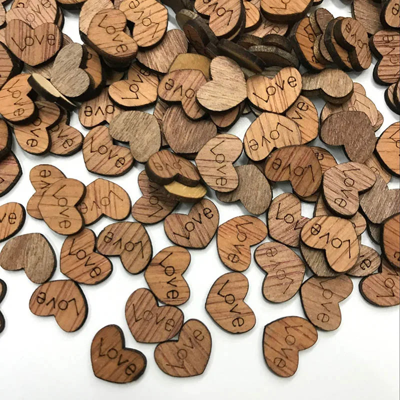A pile of small, wooden heart-shaped tokens engraved with the word "love," scattered on a white surface.