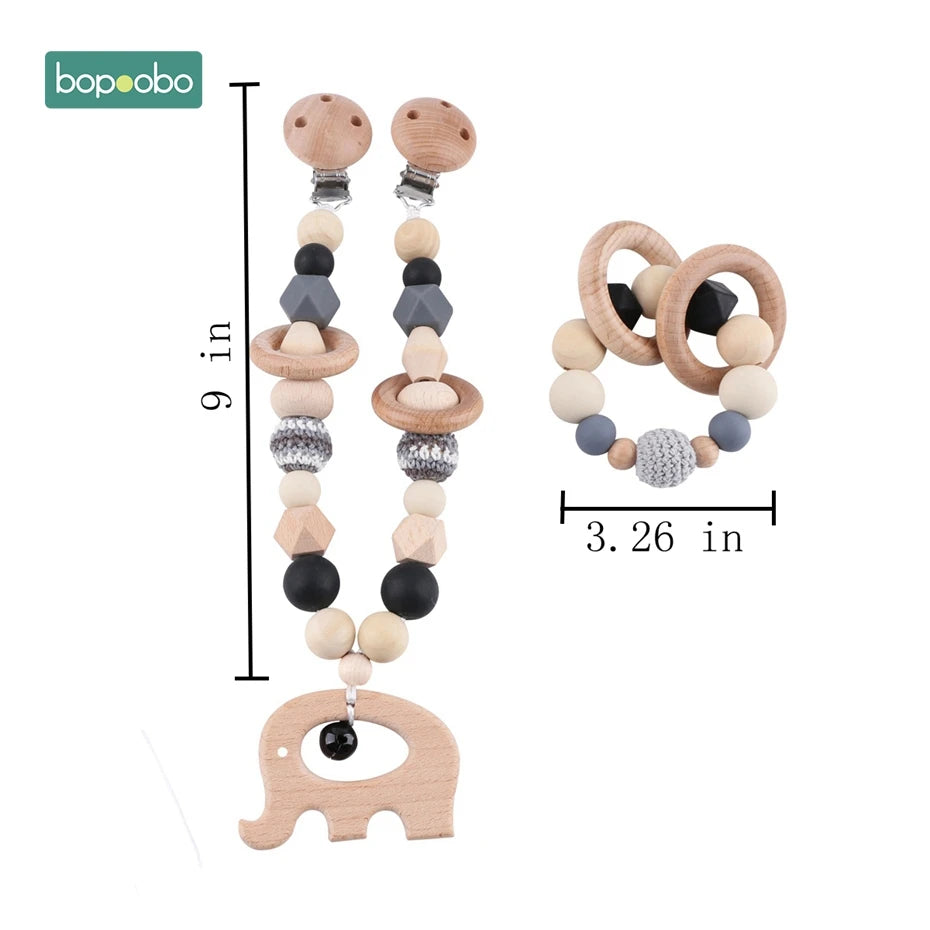 Wooden baby pacifier clip with geometric beads, elephant charm, and teething ring with beads. Dimensions shown as 9 inches for the clip and 3.26 inches for the ring.