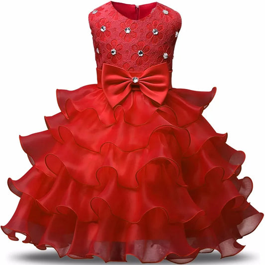 Red girl's dress with layered ruffled skirt, lace bodice adorned with rhinestones, and a large bow at the waist. Elegant and perfect for special occasions.