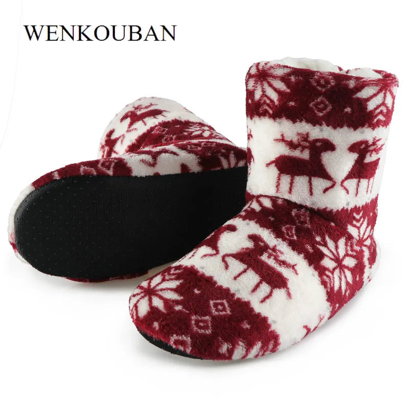 Plush winter slippers with red and white patterns featuring reindeer and snowflakes, paired with black soles.