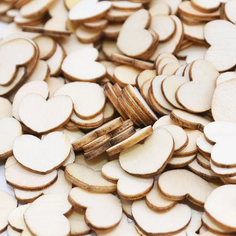 A pile of small, wooden heart-shaped pieces with smooth, light-colored surfaces and darkened edges scattered randomly.