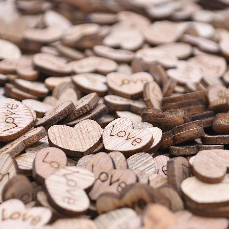 A pile of small wooden heart-shaped pieces, each engraved with the word "love." The pieces are made of light and dark wood, creating a textured, warm and inviting visual.