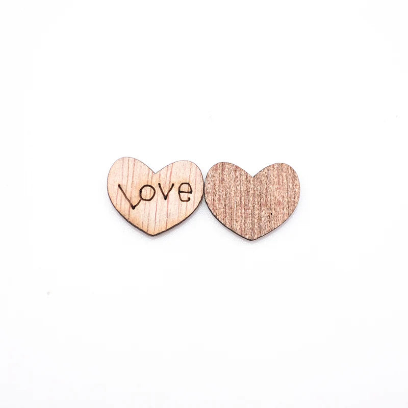 Two wooden heart-shaped cutouts on a white background; the left heart is engraved with the word "love," while the right heart is plain without any text.
