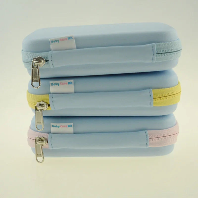 Three stacked blue zippered pouches labeled "Baby Care Kit," each with a different colored zipper: blue, yellow, and pink, on a light background.