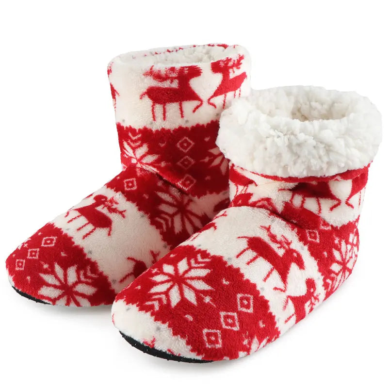 Red and white fleece slippers with a festive reindeer and snowflake pattern. Cozy design features a fluffy white interior lining, ideal for cold weather comfort.