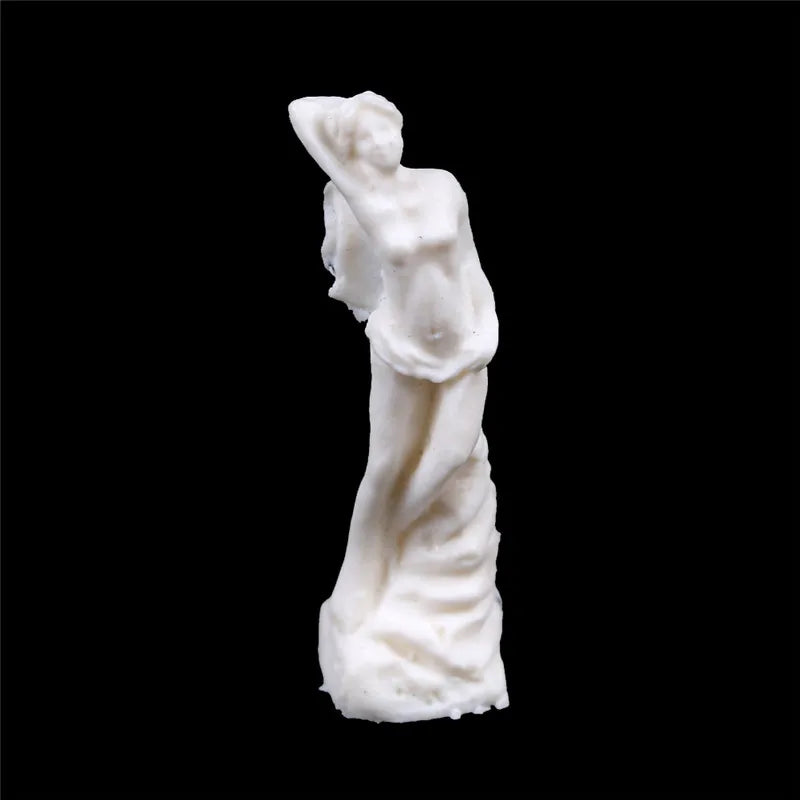 A small, white sculpture of a standing female figure with one arm raised over her head, set against a black background. The sculpture has a smooth, flowing form.