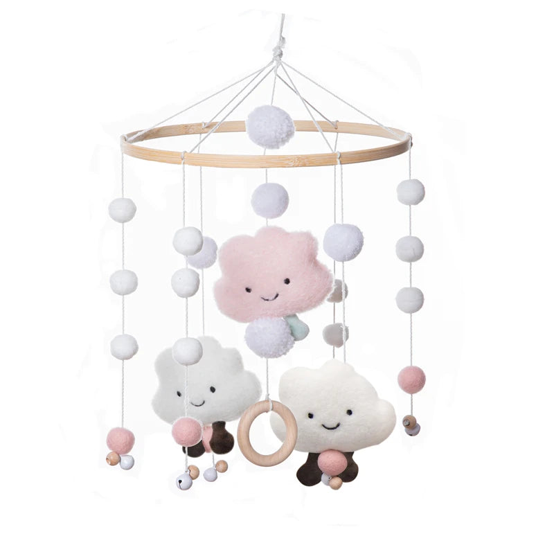 A whimsical baby mobile with hanging pastel-colored clouds and pom-poms, featuring smiling faces and a wooden hoop. Designed for nursery decoration, suspended from a wooden ring.