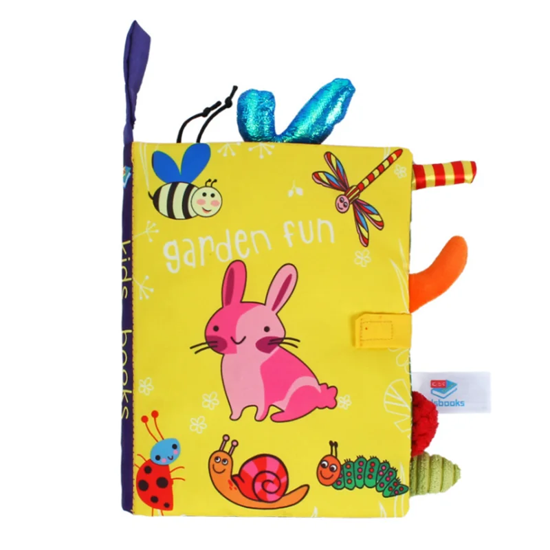 Bright, soft children's book titled "Garden Fun" features playful illustrations of a rabbit, bee, dragonfly, and snails on a yellow background with colorful fabric tabs.