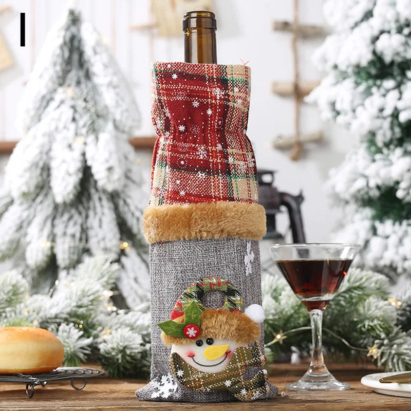 Festively decorated wine bottle with a plaid and furry cover, featuring a snowman design. It sits on a table with a filled glass, surrounded by snowy pine decorations.
