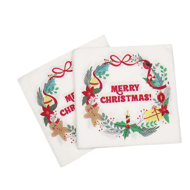 Two white napkins with a festive Christmas design featuring a wreath, gingerbread man, and poinsettia, along with "Merry Christmas!" in bold red letters.