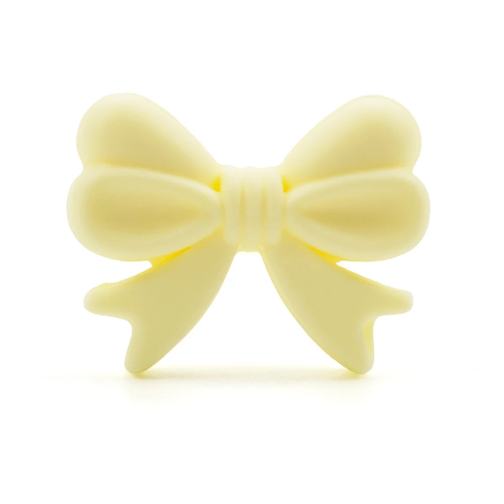 Creamy yellow bow-shaped soap with smooth, rounded edges, set against a plain white background.