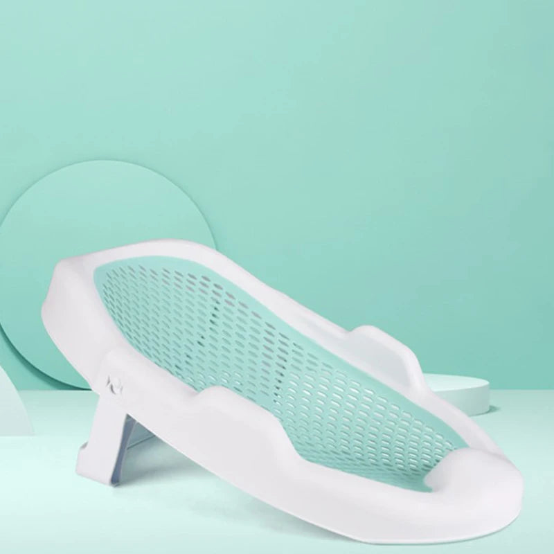 White plastic baby bath support with a mint green mesh backrest, set against a matching mint green background with circular shapes.