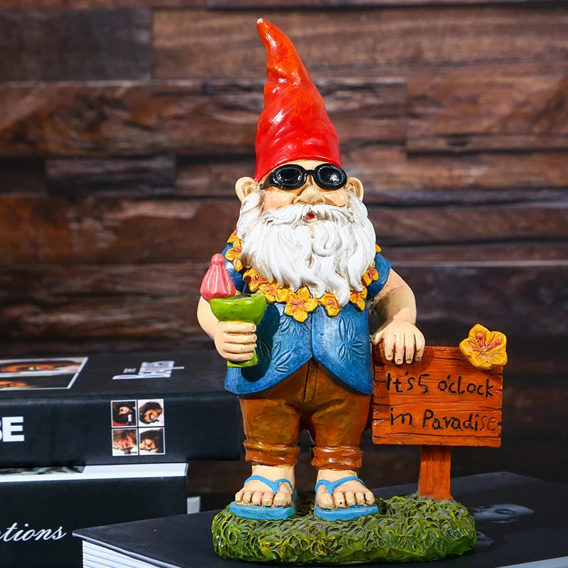 A garden gnome with a red hat, sunglasses, and a floral lei holds a drink, standing next to a wooden sign reading "It's 5 o'clock in Paradise" on a grass base.