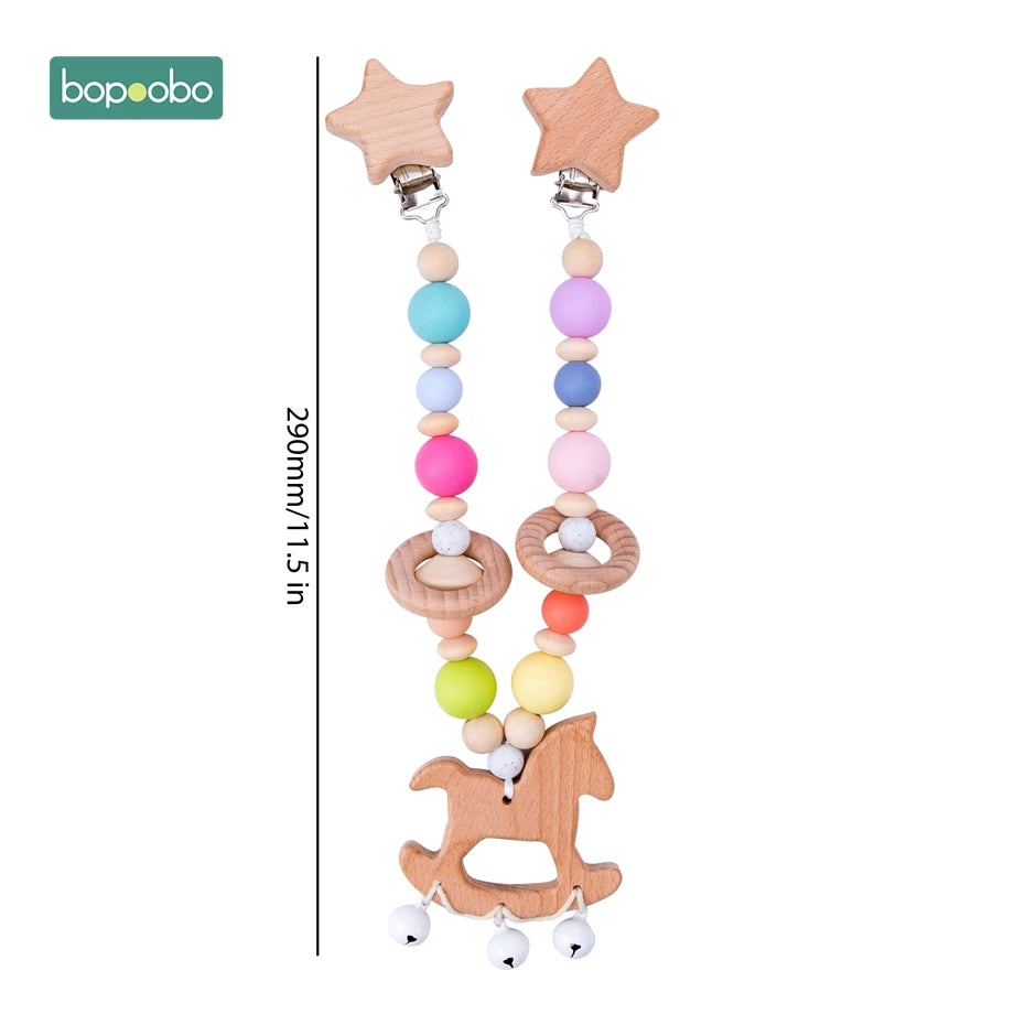 Colorful beaded baby pacifier clip with wooden star clips and a horse shape at the bottom, measuring 290mm (11.5 inches). Includes silicone beads and bells.
