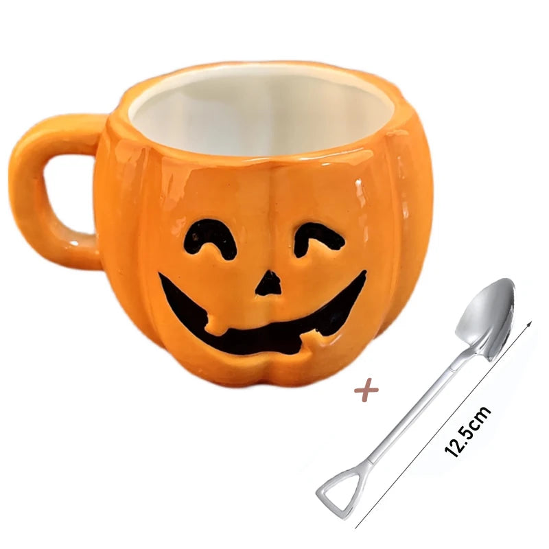 Orange pumpkin-shaped mug with a carved smiley face design, paired with a silver spoon measuring 12.5 cm.